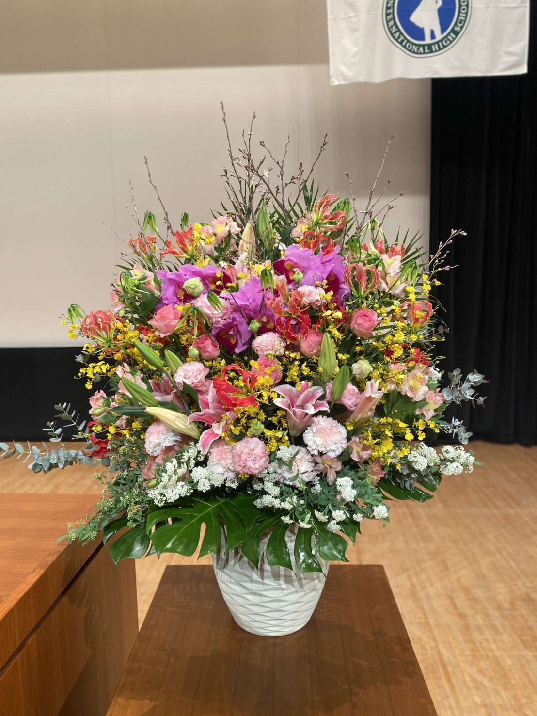 蘭と洋花の品のある大き目な壇上アレンジメント　卒業、入学式などの式典にお勧め