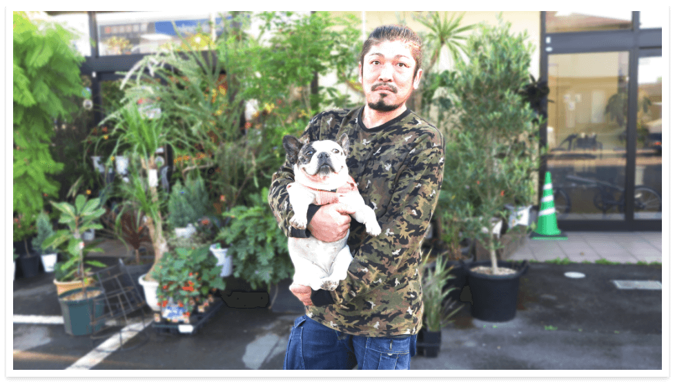 Amiのお花屋さん代表長屋篤が犬を抱っこしている